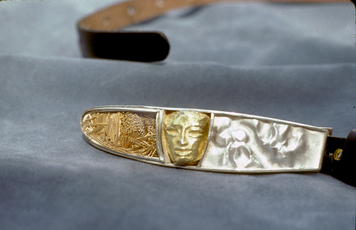 Toza, belt buckle, silver and gold with face and eyeglass lens, 1970s